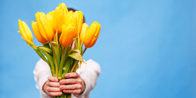 persona con ramo de tulipanes amarillos